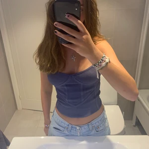 Korsett topp från Zara - Jag säljer en jätte snygg mörk grå, korsett topp i stretchigt material från Zara. Den är i storlek XS men eftersom den är i stretchigt material så passar den även om man har en större storlek. Buda!!🥰👩‍❤️‍💋‍👩