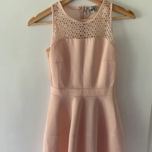 Rosa klänning med detaljer - Fin klänning som blivit för kort. Mesh i bak och paljetter på framsidan. Använd en gång. Enda defekten är de små ”revorna” som ses på bild 3. Står storlek 8 men passar S. Ramar in midjan superfint! Köpt på Nelly. Går att få bilder med klänningen på i chatten!