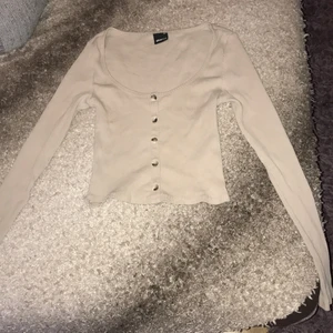 Långärmad crop top från Gina Tricot! - Säljer denna snygga Beiga långärmade crop toppen som jag inte använder längre jätte snygg verkligen💘Den har knappar i vit och lite svart/brun färg!🤍🙌🏼FRAKT:35 PRIS:65kr