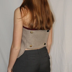  Bandeau top med knappar - Sandfärgad bandeau top med knappar i ryggen. Gjord av restmaterial från jacka! Ursprungligen från H&M som är omgjord av Scannable UF. Genom att skanna en QR-kod som finns fäst på plagget kan du läsa mer om materialet och dess miljöpåverkan!✨✨