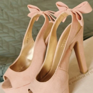 Ljusrosa sammet klackskor.  - Ljusrosa klackar. Nyskick. Använda 1 gång. Rosetter i bak. 