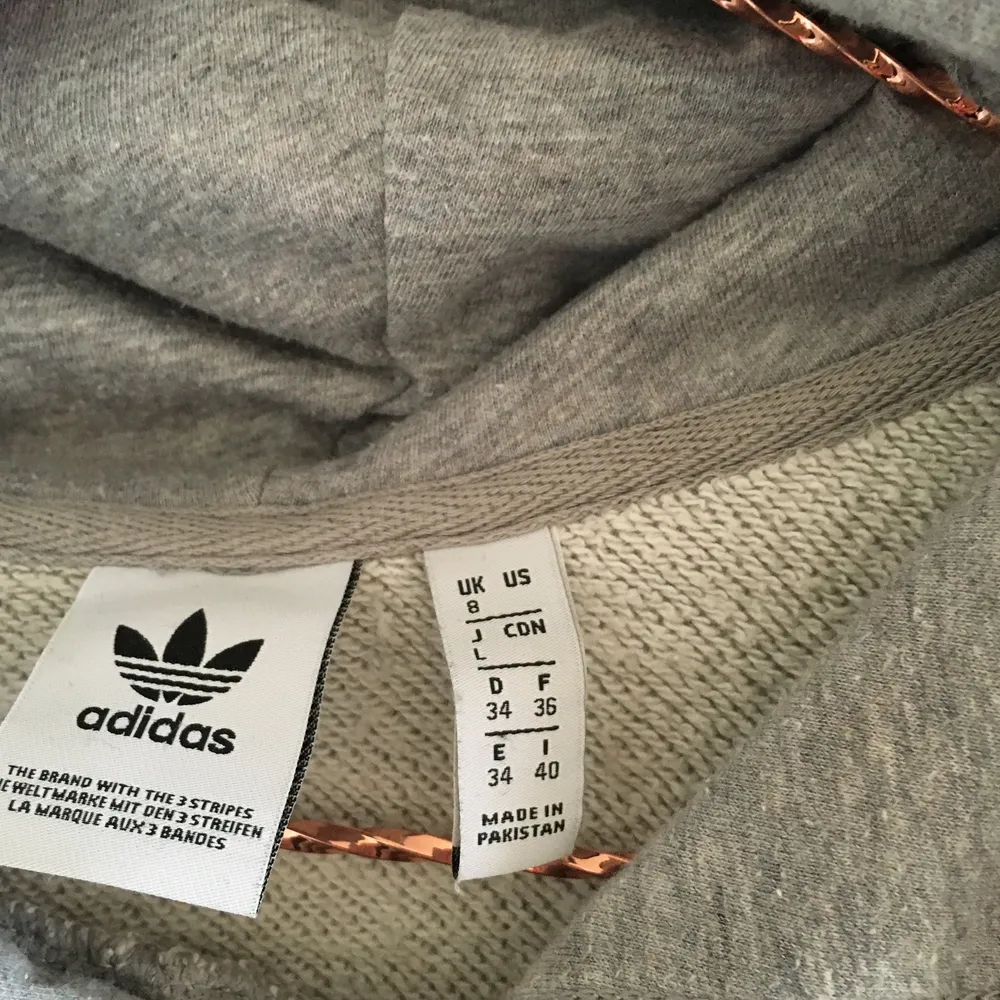 Ljusgrå Adidas huvtröja med tre-foil logo fram och stor genomgående ficka. Använd men i fint skick. Storlek 34-36, rymlig. UK 8. Hoodies.