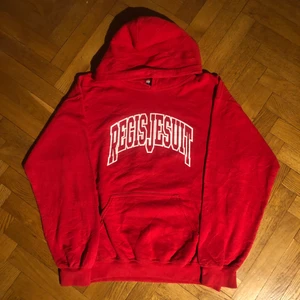 Regis jesuit - vintage hoodie - Fin röd hoodie med college tryck. Perfekt att ha som oversized eller regular fit. Köpt på Ross som är en amerkansk secondhandbutik. Perfekt skick