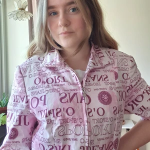 (38) Rosa t-shirt / polo / jacka Gerry Weber  - Jättehäftig tjockare kortärmad jacka i rosa med lila text. Två fickor. Går att bära öppen, stängd med skjortkrage och med hög krage. Många möjligheter och sätt att styla! Tyvärr lite för stor på mig och känner att jag har något kort nacke för att känna mig bekväm🙈