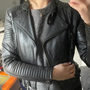 Zara bikerjacka - Bikerjacka från Zara - välanvänd! Strl M. Skinnjacka i fejkläder från Zara. Jackan är välanvänd och halvt sliten men har hållit väl och är fortfarande fin i kvaliten 