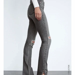Jeans från Zara - Gråa jeans från zara med hål i knäna och slits längst ner. Storlek 34, jag är 163 cm och de är lite korta på mig.