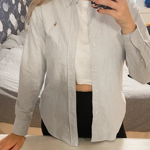 Ralph lauren tröja strlk S - Jättefin och knappt använd Ralph lauren skjorta! 🌟Vit och ljusblå, randig. Fin att ha knäppt men också att ha öppen över ett linne 🥰 säljer för att den är lite för liten för mig💞. Är sann i storleken skulle jag säga!💖
