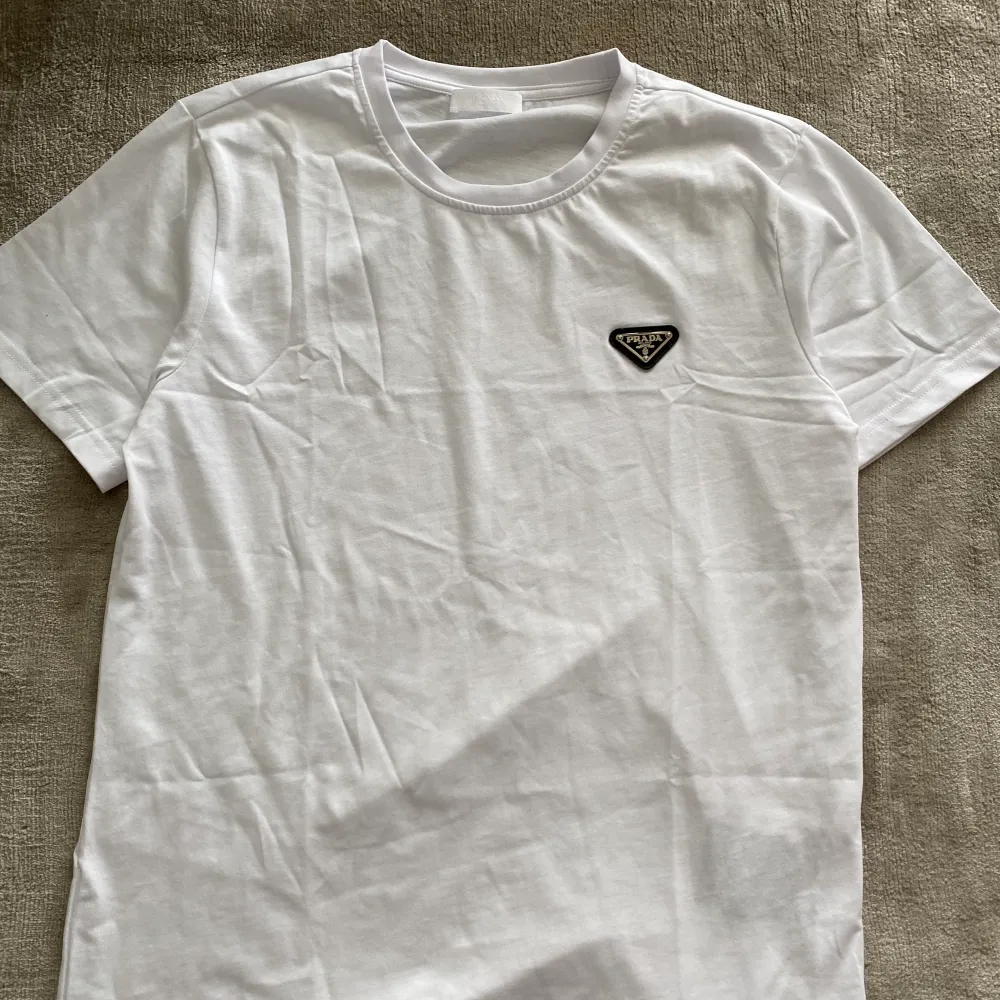 Prada t shirt i väldigt bra skick säljes. Vid snabb affär utlovas bättre pris. Kan frakta med spårbart i hela Sverige. Inga skambud tack!. T-shirts.