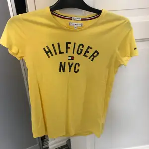 Gul Tommy Hilfiger T-shirt i storlek 164 (passar XS & S). Superfint skick, endast använd en gång! Nypris runt 300kr.