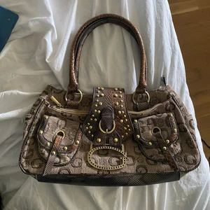 Guess väska - Lägger ut igen pga oseriösa köpare, buda endast om du vill köpa den! Säljer min mammas gamla guess väska då den inte har får mycket användning, vet ej om den är äkta eftersom de var hennes gamla men den är i super bra skick🤎 Frakt kostar 66kr