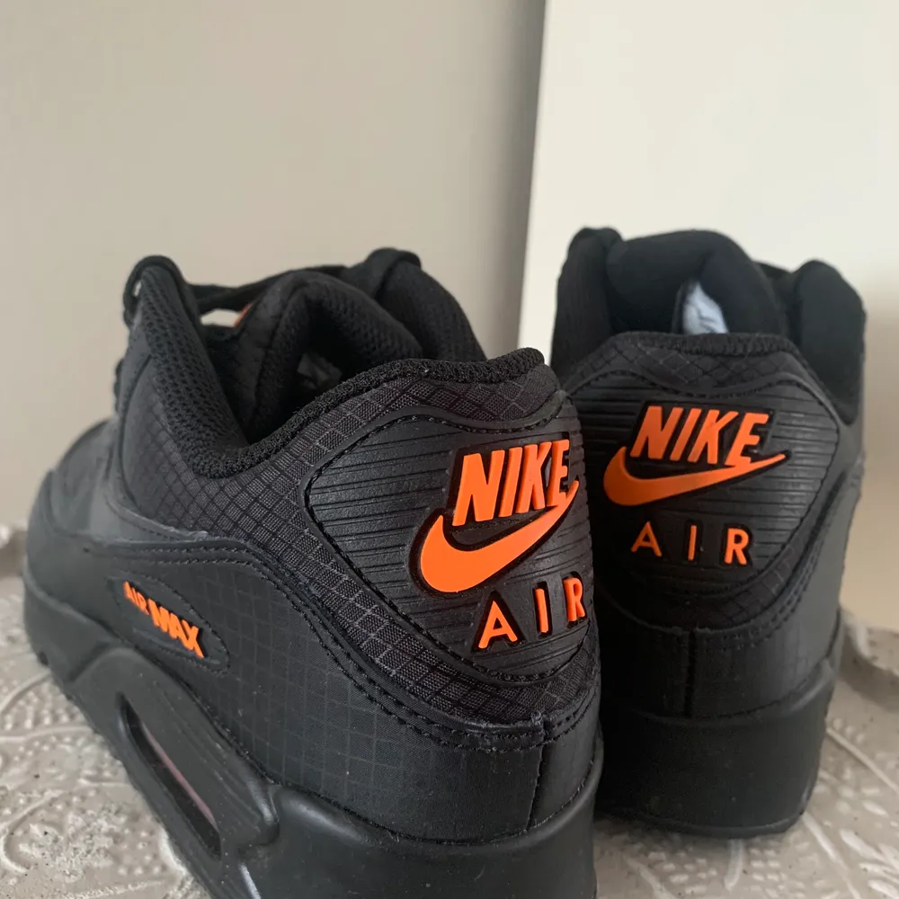 Ett par nya svarta Nike Air Max med orangea detaljer. Dessa är endast använda en gång men sedan insett att dem var för små, skriv för frågor 🙌🏼. Skor.
