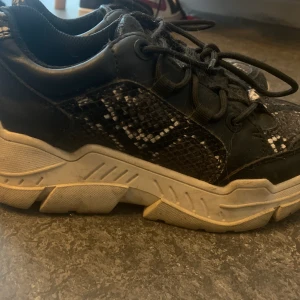 Orm mönstrade skor - Skor med hög sula i strl 36,5 i orm mönster, använda men inte mycket, orginalpriset var 500kr. Vet ej frankten helt säkert men köparen står för den💗