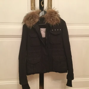Zadig Jacka - Säljer denna svarta MIlitary Jacket från Zadig & Voltaire. Avtagbar krage med äkta päls.  Storlek S, passar både storlek 36 samt 38. Fina detaljer, som roade kanter, silvriga stjärnor, Z&V logga.  Fint begagnad skick.                                                                      Börjar priset på 1500 sedan är det bara att buda💕