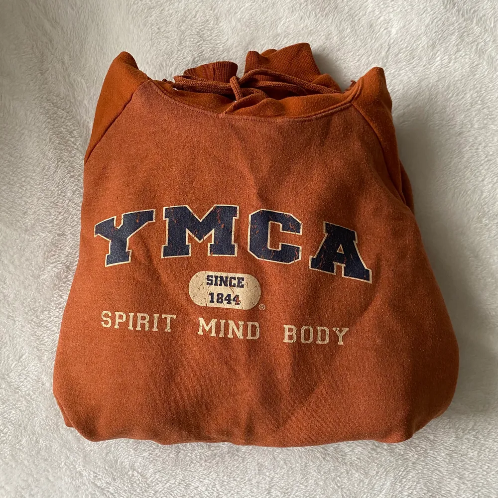 En YMCA Hoddie i fint skick. Skulle tippa på storlek M. Färgen är en blandnings av mörk orange och brun.💕 Köparen står för frakten.. Hoodies.