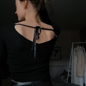 Svart topp -  Svart topp med fin knytning i ryggen. Storlek XS. 