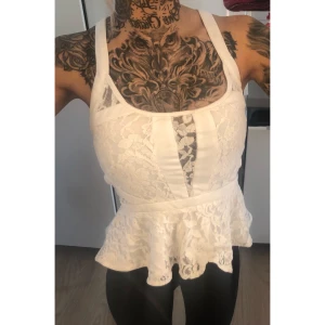 Nelly - Vit topp, strl 34 - Vit peplumtopp med spets från Nelly, storlek 34.