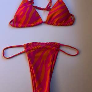 Supersnygg bikini med orange och rosa zebramönster🧡💓 Toppen har uttagbara ilägg och båda delarna är i strl Xs, helt oanvänd (endast testad)