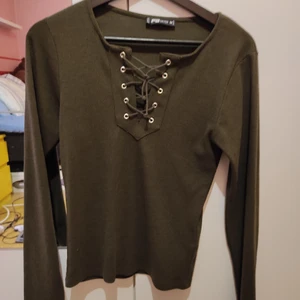 Tröja med snörning - Mörkgrön lätt ribbad tröja med snörning. Sparsamt använd. Väldigt bekvämt material. Står som M men funkar nog som S också.