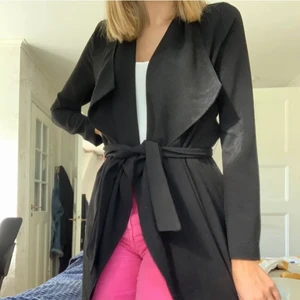 Svart kappa från Only - Jättesnygg svart kappa från only i storlek xs, men jag skulle säga att den även passar för dom som har s. Den går att knyta i midjan och slutar en bit under rumpan. Den är använd mycket lite så den är i bra skick! Frakt ingår inte i priset🥰