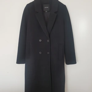 Svart MONKI kappa - Cute black coat, great for autumn and winter, in a very good condition. For some reason it didnt take my whole photo of it, but can send it of course. Size is XS. It is 107cm long and 47×2cm wide around the chest. Material is ullmix. Post is 67:- by Schenker. Meet up is available, too :)