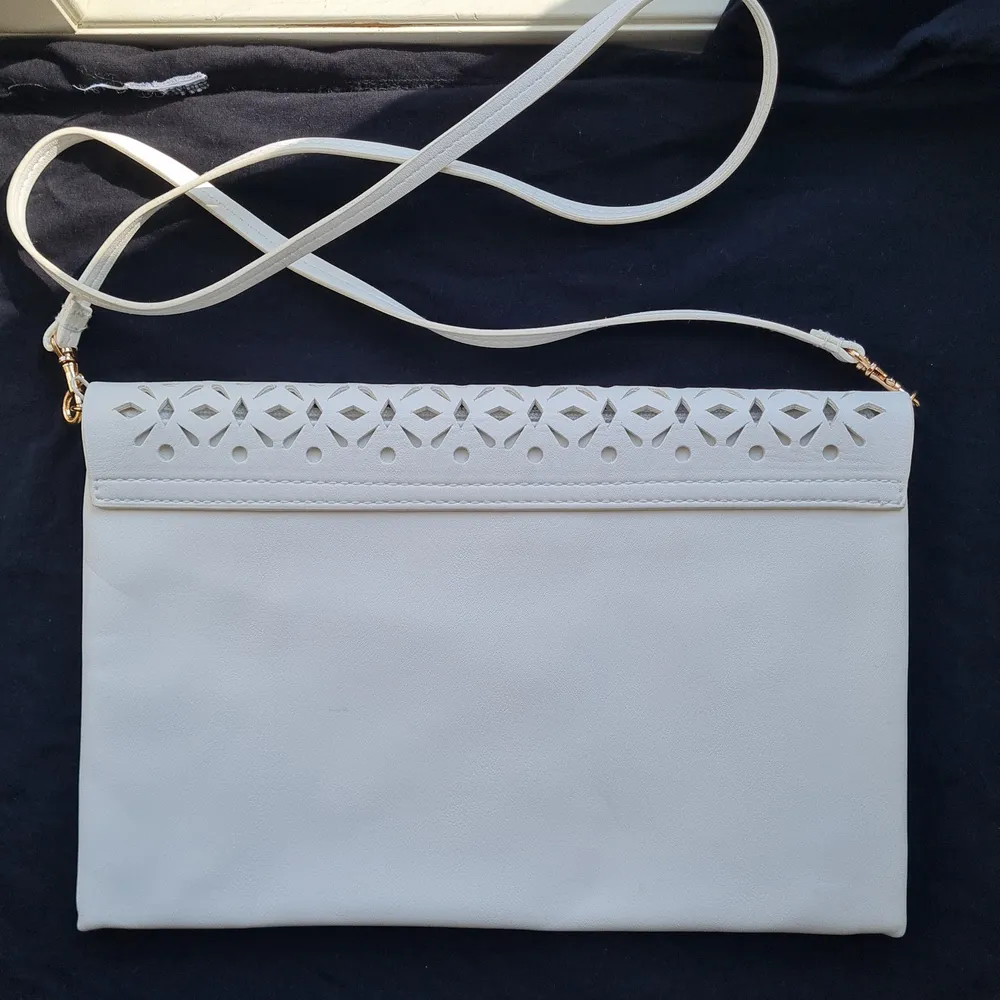 White openwork clutch with a detachable strap and a zipper. Dimensions 30x20 cm.. Väskor.