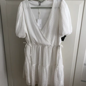 Klänning från Nelly/ NLY Trend  - Söt vit klänning, passar jättebra till student/konfirmation. Aldrig använd, köpt februari 2021 för 300kr. Sött prickigt tyg, små knyt på båda sidorna i midjan - kan dra åt eller släppa ut. I kortaste laget för mig (175), passar bättre om man är kortare. 