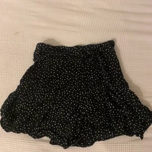 Prickig kjol - En jättesöt svart kjol med vita prickar. Det finns ett band i midjan som man kan ta av om man vill. Det är ett par undershorts som sitter i kjolen och som inte går att ta av. 