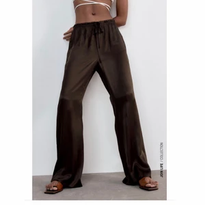 Zara byxor - Nypris 259kr Bruna byxor Zara. Råkade göra ett hål när jag provade så kan inte lämna tillbaka prislapp kvar. Köpte XXL för ville att de skulle vara långa. Passar någon som är kanske 175 i längden och som har L i midja. Går att dra åt med band. Frakt 57kr
