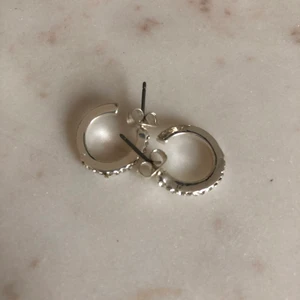 Silvriga örhängen  - Silvriga örhängen som aldrig använts, fint skick! 