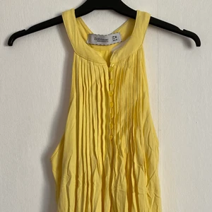 Fin sommarklänning - Somrig gul klänning i skönt material! Fint skick. Stora fickor på sidorna, knappar uppe vid halsen