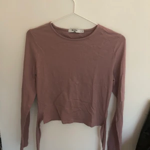 NA-KD topp - Smuts lila långärmad topp man kan knyta. Använt ett fåtal gånger, jättefint skick! 