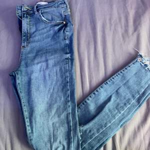 Blå högmidjade GinaTricot jeans med slitningar på knäna. Använda sparsamt, storlek S. Hör av er vid frågor!