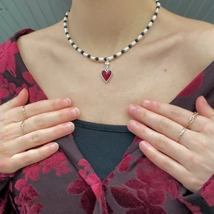 Halsband hjärta  - Handgjort halsband av mig med en berlock som är ett rött och silvrigt hjärta. Halsbandet är gjort på äkta sötvattenspärlor och halvädelstenar i obsidian.🖤 Halsbandet har en förlöngningskedja på 5cm gjort i rostfritt silverpläterad stål, som gör halsbandet justerbart. Ädelstenen obsidian har egenskaper som absorberar negativa energier och bär rå beskyddande egenskaper✨ Har två av detta halsbandet i lager :) Kontakta mig gärna om du har frågor eller vill köpa❤️