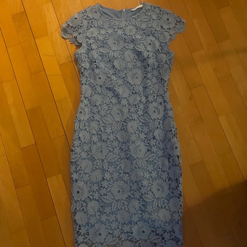 En blå klänning med blomm mönster. Aldrig använd. Helt ny. Original pris: 675kr. Klänningar.
