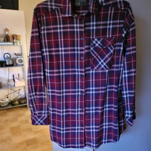 Skjorta  - Rutig skjorta som är något längre. Knappt använd. Från djur och rökfritt hem. Kan skickas mot fraktkostnad 