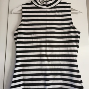 Randigt crew neck linne, S/M - Säljer detta fina randiga linne med lite högre krage. Har använt det ett fåtal gånger och därför i bra skick:) lappen är avklippt men skulle gissa på en storlek S/M då det inte sitter tajt på mig som har XS/S I tröjor. Men jätte skönt och mjukt material💋