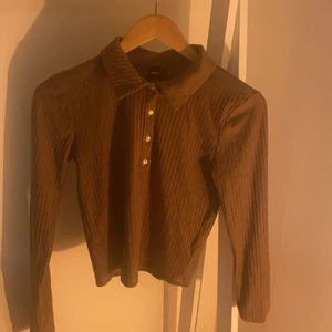 Topp med knappar - Brun topp med knappar som från början var gul men har färgat den. Använder inte pga för liten.