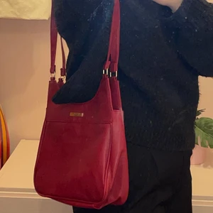 Röd väska - Axelbandsväska/handväska. Köpt secondhand så vet tyvärr inte vilket märke det är.