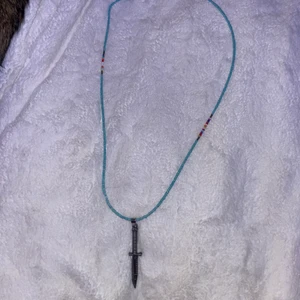 kniv halsband med pälor - ett väldigt cool halsband med blåa pälor runt halsen samt några andra färger längst upp vid toppen, samt kniven i silver,halsbandet går att skystera men är i normal stolek väldigt långt och går ner till bröstet på ett ungefär.