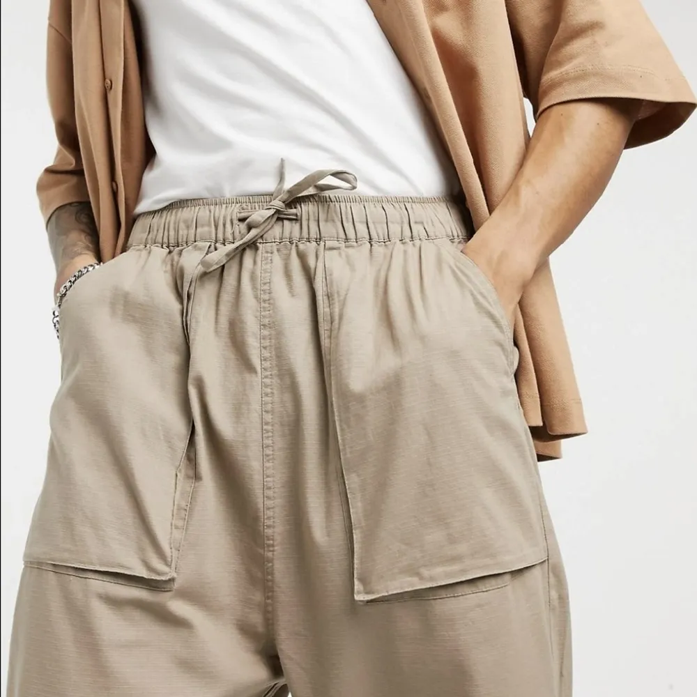 Bekväma byxor från Asos Design i toppenskick! Knappt använda, och säljer då passformen inte funkade för mig. De är i storlek W30 L32, och går att dra åt så mycket man vill i midjan. De går till anklarna på mig som är 168cm!. Farkut & Housut.