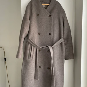 H&M limited edition Ullkappa - Lite oversized fin och varm ullkappa med unikkarge i storlek 38. Kappan är ett limited-edition plagg. Fickfodralen har syts själv men inget synligt. 