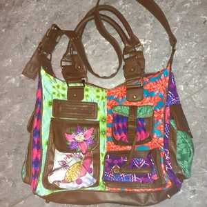 DESIGUAL läckert mönstrad väska. Fin - Jättefin väska med mycket fack. Härligt blandat mönster. Inställbart axelband. Jättefint skick. Mått: ca 43x36x12cm