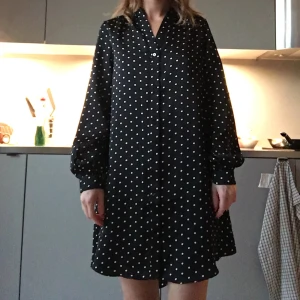 Prickig klänning från H&M  - Jättefin prickig klänning. Bra längd och passar till det mesta. Snyggt till utsvängda jeans nu på hösten! Väldigt fint skick!