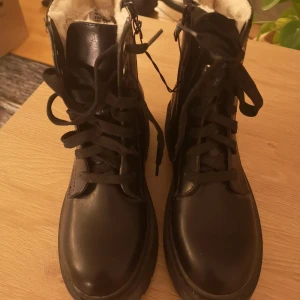 Svarta kängor stl 37 (Nya)  - Svarta kängor stl 37 med foder inuti. Nya, aldrig använda då storleken blev fel för min dotter. Både snörning och dragkedja. Lite tjockare sula. Nypris 500 kr  Finns i Hökarängen 