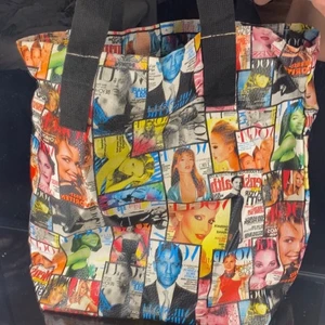 Väska  - En stor strand/skol mm väska. Ett stort utrymme med ett litet fack på sidan. Hela utsidan på väskan är ett lite vintage med massa vouge sidor med en mängd olika kändisar. 