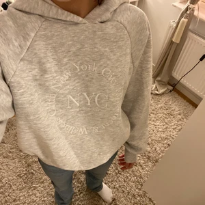 Grå hoodie - En jättefin och oanvänd grå hoodie med vit text på.