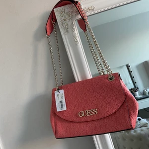 GUESS axelremsväska 🥰 - En oanvänd GUESS axelremsväska🥰 En super snygg väska nu inför sommaren med den otroligt vackra färgen. Den ger en stark 90 tals vibe & ger outfiten en touch.🦋⚡️✨ Jag har inte fått chansen att använda den & därför så säljer jag den. Köptes för 1249kr och jag säljer den för 620 men priset kan diskuteras vid snabb köp.🙏🏽