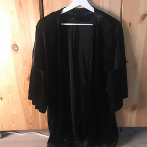 Kimono Sammet - Svart kimono i sammtsmaterial. Använd en handfull gånger. Storlek S men passar även M. Svaga smala ränder på. Lågt pris pga möts ej upp utan skickar på post och köpare står för frakt! :)