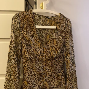 Leopard tröja - En jättesnygg leopard tröja med fluffiga ärmar. Knappar i mitten och har sömmar under brösten så de formas jättefint! Aldrig använd pga för liten :/
