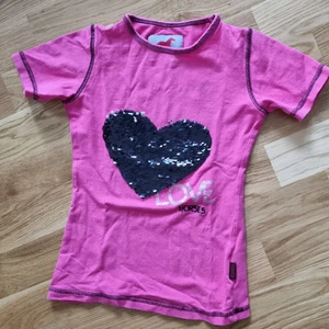 Hästtröja storlek 116 - Hästtröja från intersport. Storlek 116. Bra skick. Har glitter man kan ändra svart/silver. 